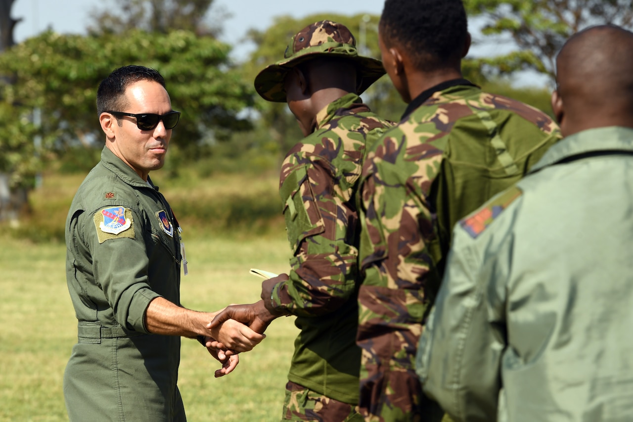 Air Force officer shakes hands with local soldier.