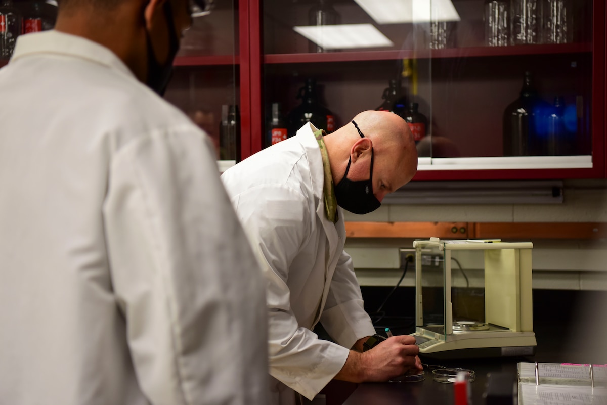 U.S. Air Force Senior Airman Michael Moore, a 354th Logistics Readiness Squadron (LRS) fuels laboratory technician, watches Col. David Berkland, the 354th Fighter Wing commander, label a fuel sample during a wing leadership immersion at Eielson Air Force Base, Alaska, Sept. 22, 2020.