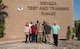 A group poses for a photo in front of a building.