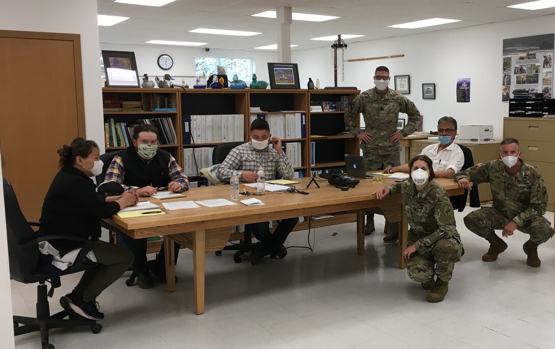 U.S. Army Reserve Lt. Col. Hugh Dougalas, governance and participation section chief (center left), Capt. Sarah Robinson, public health nurse (center right), Col. Bradford “Brad” Hughes, functional specialty team chief (right), and members of the Qawalangin Tribe (Q-Tribe) council pose while participating in a council meeting during an Innovative Readiness Training Civil-Military Partnership Leader’s Reconnaissance, Unalaska, Alaska, July 23, 2020.  IRT is a joint training concept that the Department of Defense (DOD) implemented to increase unit deployment readiness, leveraging the military contributions of U.S. Armed Forces capabilities, combined with local resources to build strong civil-military partnerships for communities in the contiguous United States and its territories.