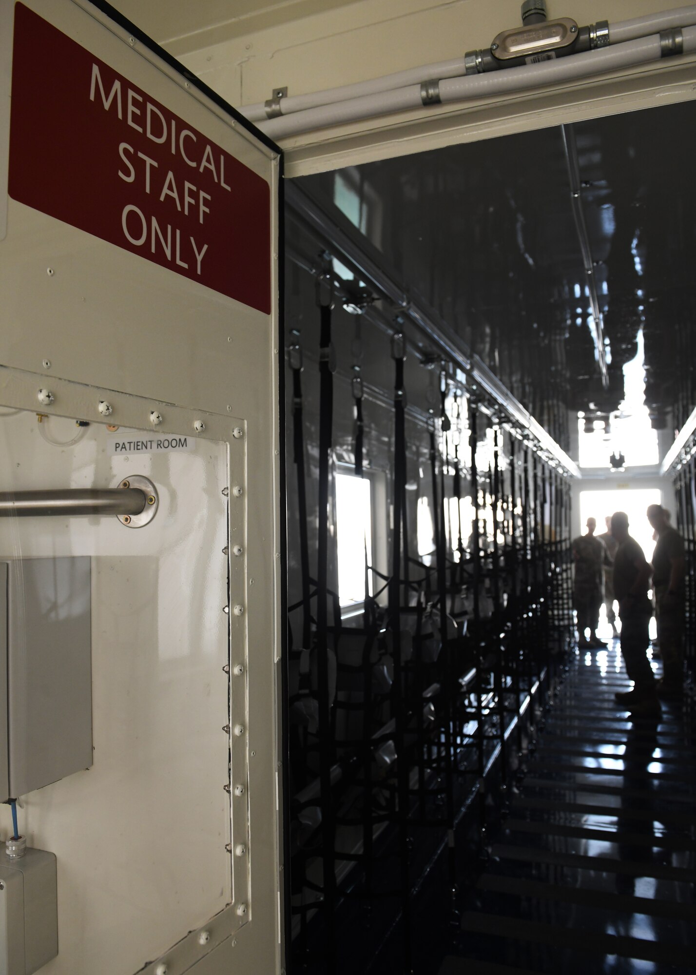 Airmen assigned to the 379th Expeditionary Aeromedical Evacuation Squadron deployed to Al Udeid Air Base, Qatar, inspect a specialized medical container designed to transport individuals with infectious diseases. The Negatively Pressurized Conex, or NPC, is configured for the C-17 Globemaster III and C-5 Super Galaxy aircraft to safely transport up to 28 passengers or 23 patients, including ambulatory and litter, around the globe. (U.S. Air Force photo by Staff Sgt. Kayla White)