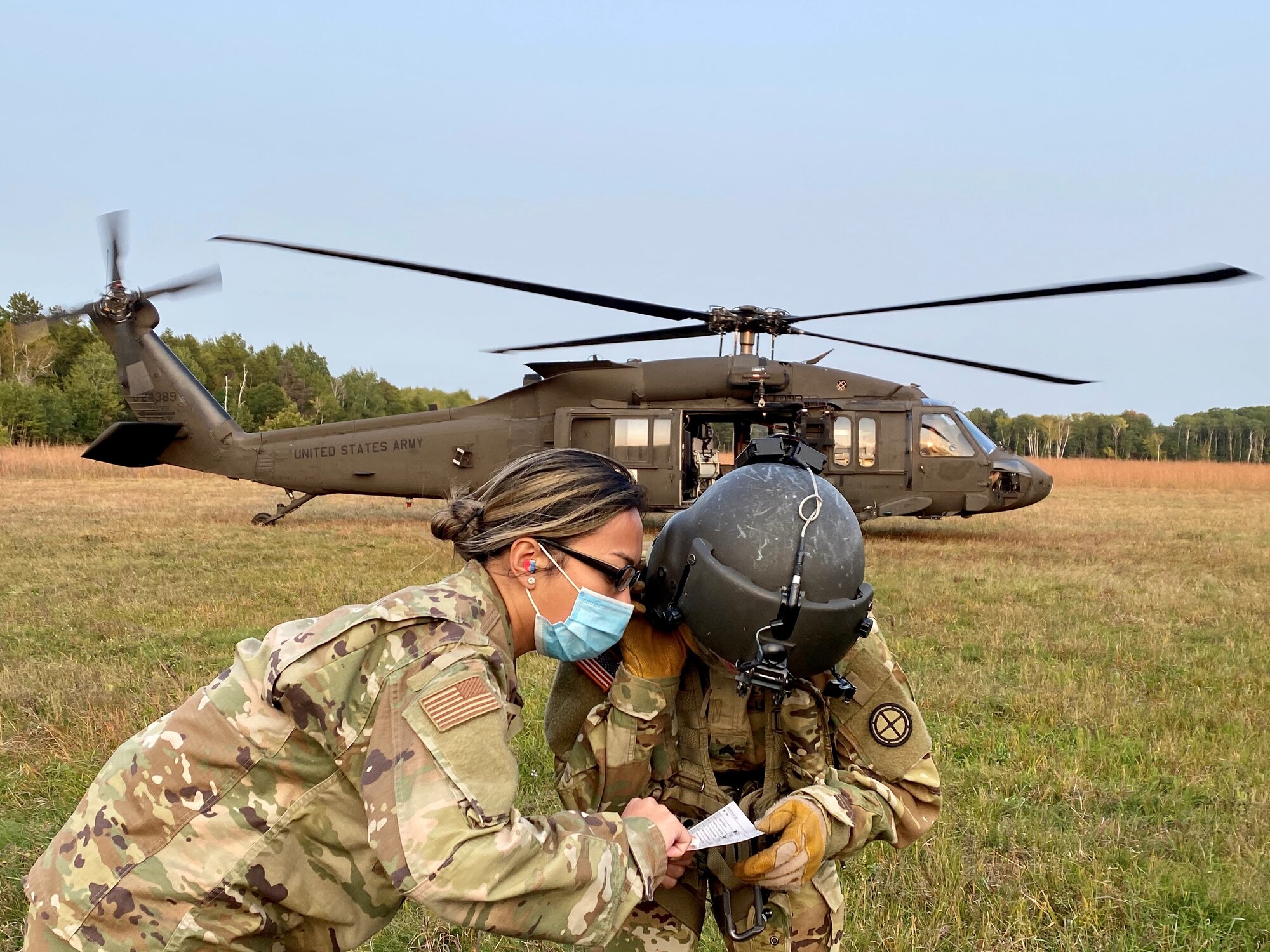 An Aerospace Medical Technician with the 148th Fighter Wing, Minnesota Air National Guard, communicates with a Critical Care Flight Paramedic assigned to the 2-211 General Aviation Support Battalion, Minnesota Army National Guard, during medical evacuation training at Camp Ripley Training Center, Minnesota on Saturday, September 20, 2020.
