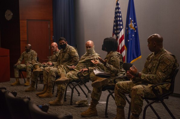 Six Airmen sitting on stage discussing issues