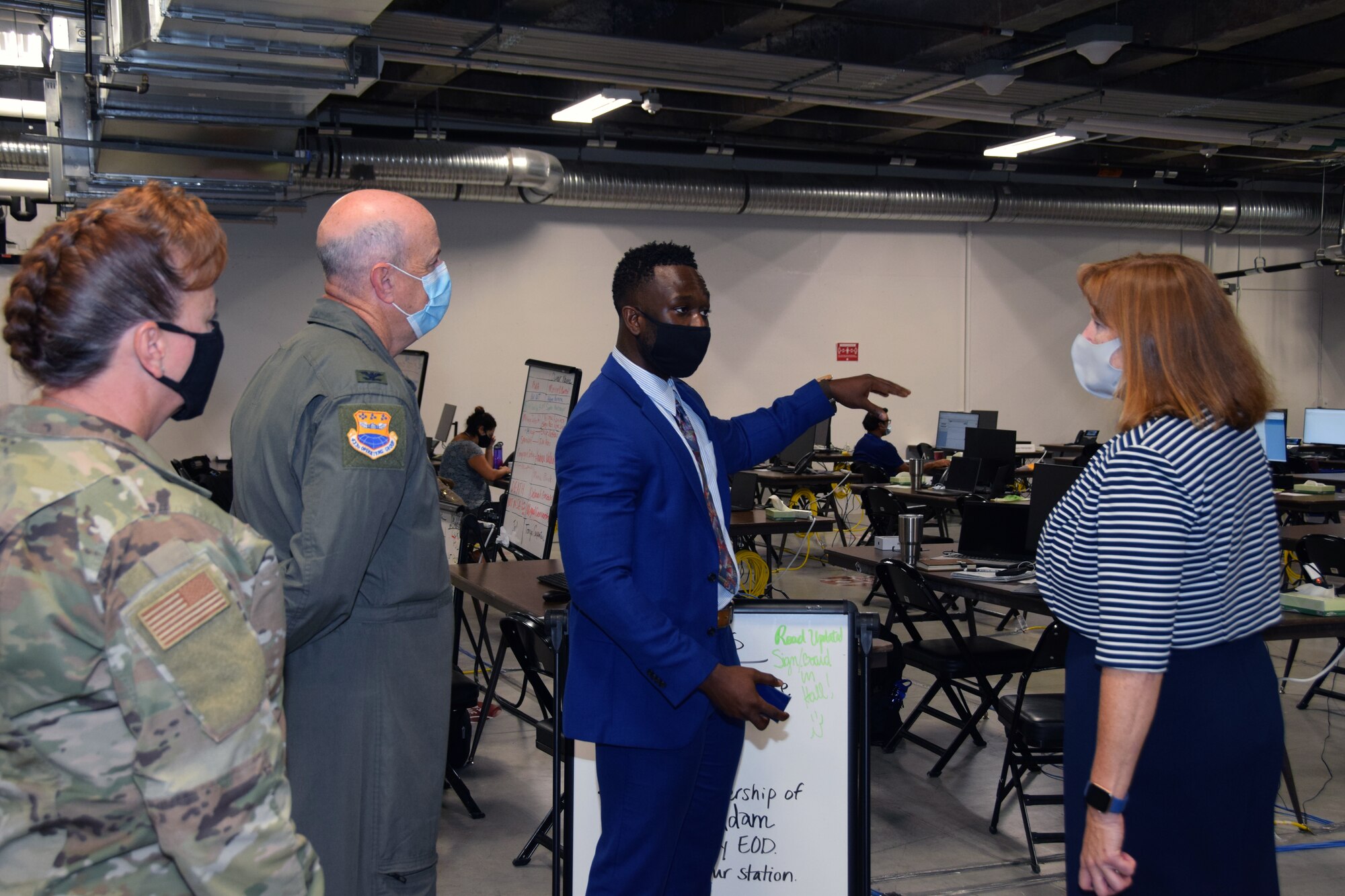 Tech. Sgt. Anthony Biakpara, 433rd Civil Engineer Squadron (blue suit), leads Chief Master Sgt. Shana Cullum, 433rd Airlift Wing command chief; Col. James C. Miller, 433rd Operations Group commander; and Kimberly Toney, Air Force Personnel Center executive director, on a tour of the Bexar County COVID-19 operations center Sept. 17, 2020 in San Antonio, Texas.