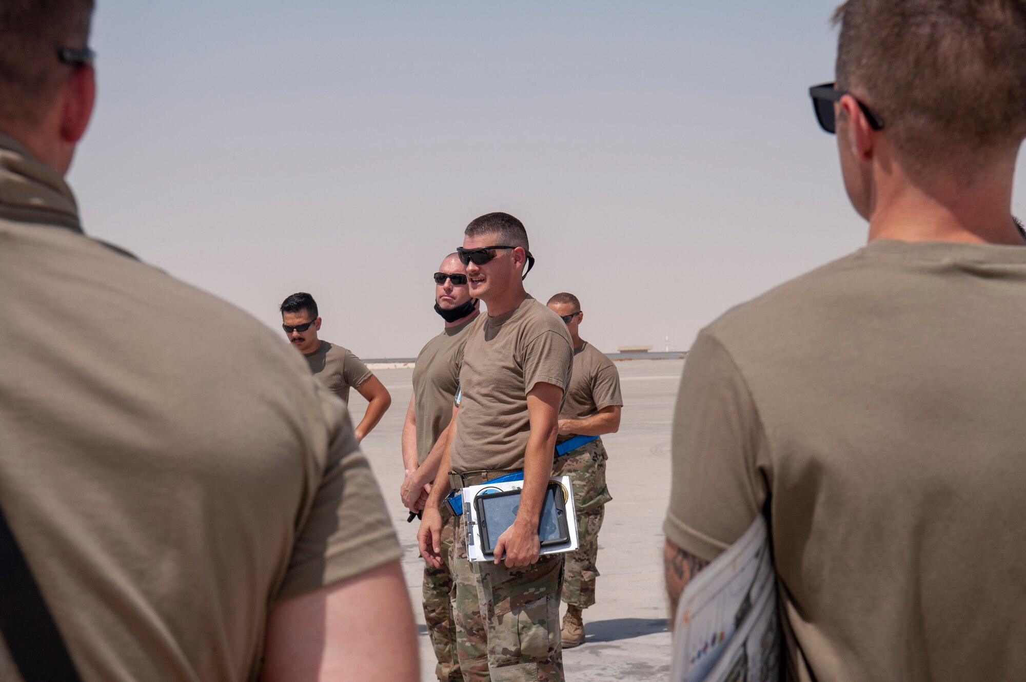 A 379th Air Expeditionary Wing maintainer briefs procedures from a maintenance perspective to members participating in a KC-135 Stratotanker aircraft hot refueling training scenario at Al Udeid Air Base, Qatar, Sept. 21, 2020. Personnel from the 379th Expeditionary Aircraft Maintenance Squadron, 379th Expeditionary Logistics Readiness Squadron and 340th Expeditionary Air Refueling Squadron attended the training. The certification they receive will enable personnel to refuel a KC-135 while one or more engines run.