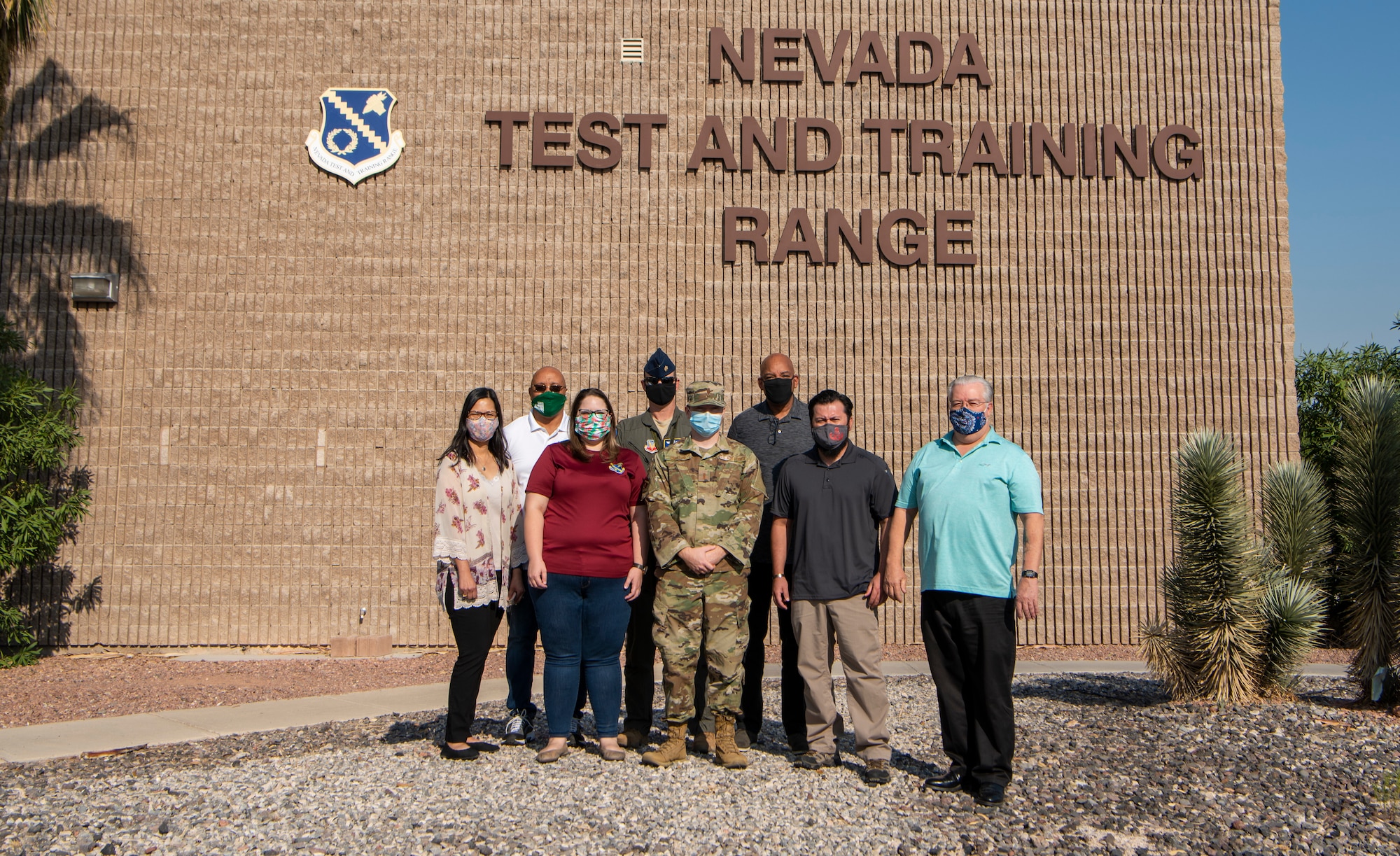 A group poses for a photo in front of a building.