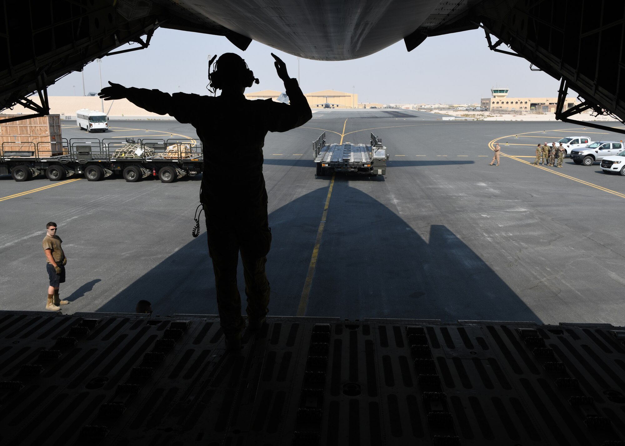 Airman 1st Class Taylor Robinson guides a Tunner 60K Loader toward a C-5 Galaxy on the flight line of Al Udeid Air Base, Qatar, Sept. 18, 2020, to off load a specialized medical container designed to transport individuals with infectious diseases. The Negatively Pressurized Conex, or NPC, is configured for the C-17 Globemaster III and C-5 Super Galaxy aircraft to safely transport up to 28 passengers or 23 patients, including ambulatory and litter, around the globe. (U.S. Air Force photo by Staff Sgt. Kayla White)
