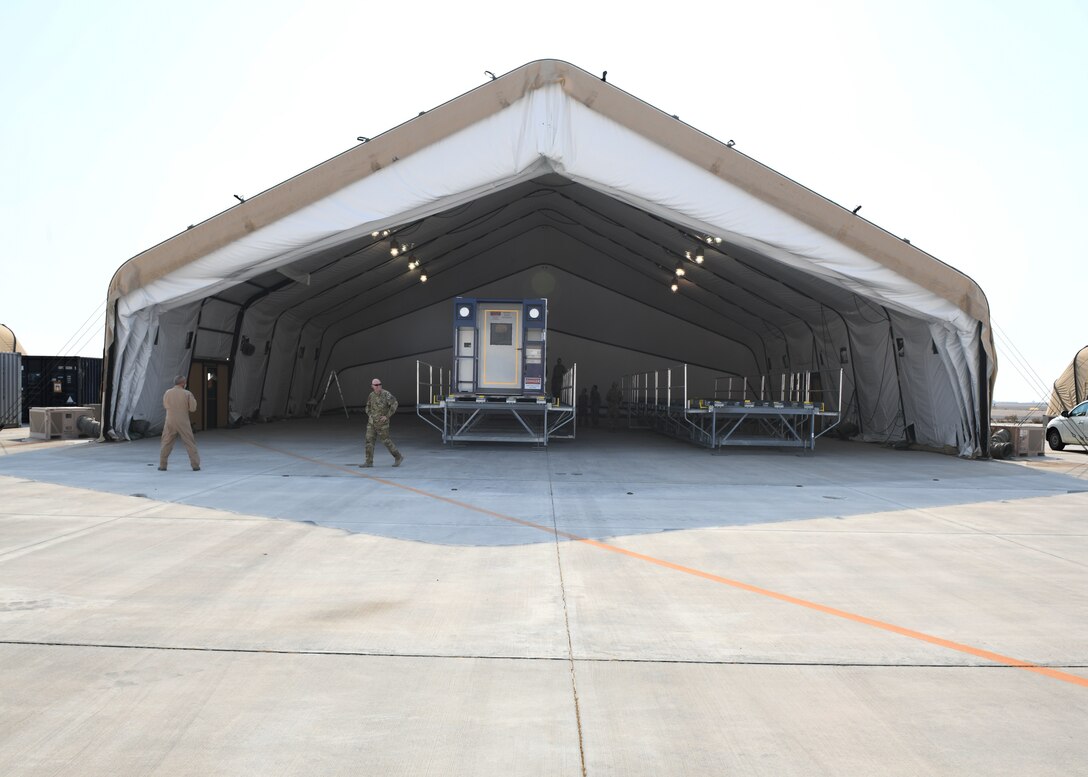 A specialized medical container designed to transport individuals with infectious diseases sits in a clamshell hangar on the flight line of Al Udeid Air Base, Qatar, on Sept. 18, 2020. The Negatively Pressurized Conex, or NPC, is configured for the C-17 Globemaster III and C-5 Super Galaxy aircraft to safely transport up to 28 passengers or 23 patients, including ambulatory and litter, around the globe. (U.S. Air Force photo by Staff Sgt. Kayla White)