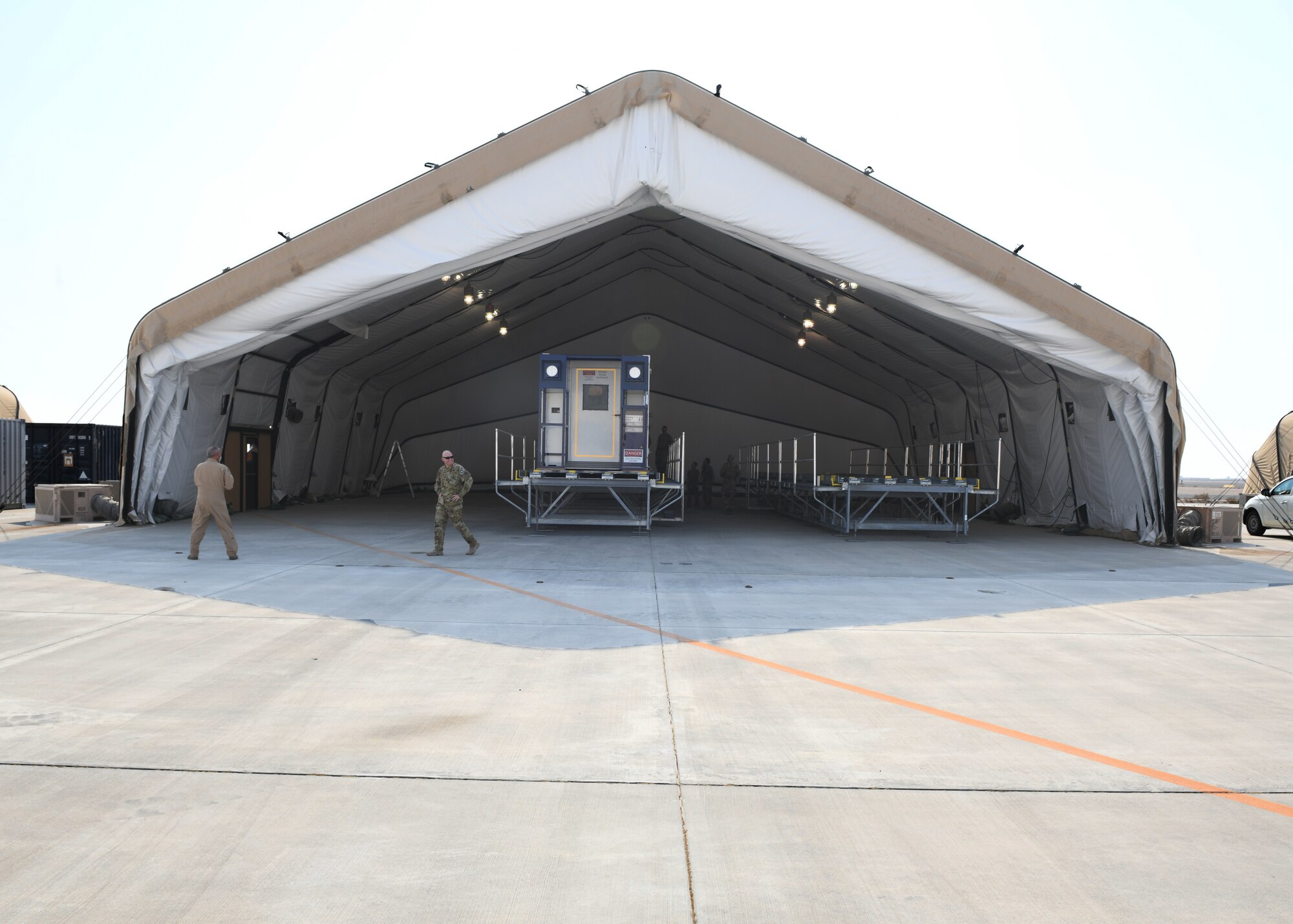 A specialized medical container designed to transport individuals with infectious diseases sits in a clamshell hangar on the flight line of Al Udeid Air Base, Qatar, on Sept. 18, 2020. The Negatively Pressurized Conex, or NPC, is configured for the C-17 Globemaster III and C-5 Super Galaxy aircraft to safely transport up to 28 passengers or 23 patients, including ambulatory and litter, around the globe. (U.S. Air Force photo by Staff Sgt. Kayla White)