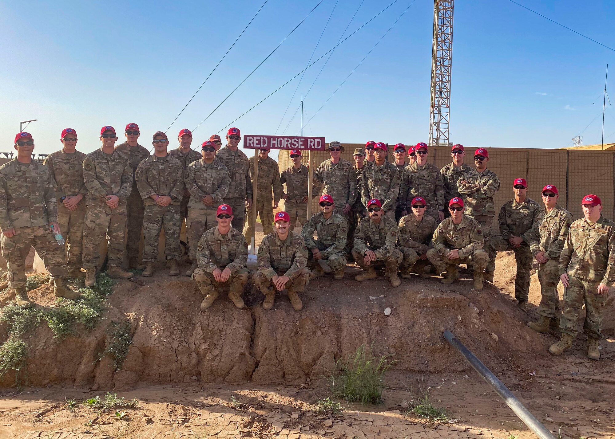 The 819th Expeditionary Rapid Engineer Deployable Heavy Operational Repair Squadron Engineers pose for a photo during a dedication ceremony after completing their long-term build at Nigerian Air Base 201, Niger, Aug. 19, 2020. In honor of the squadron’s many achievements, to include finalizing the largest Airmen-led construction project in U.S. Air Force history, the main road was named “RED HORSE Road.” The ceremony marked the end of the squadron’s continuous presence in Agadez since April 2016. (Courtesy Photo)