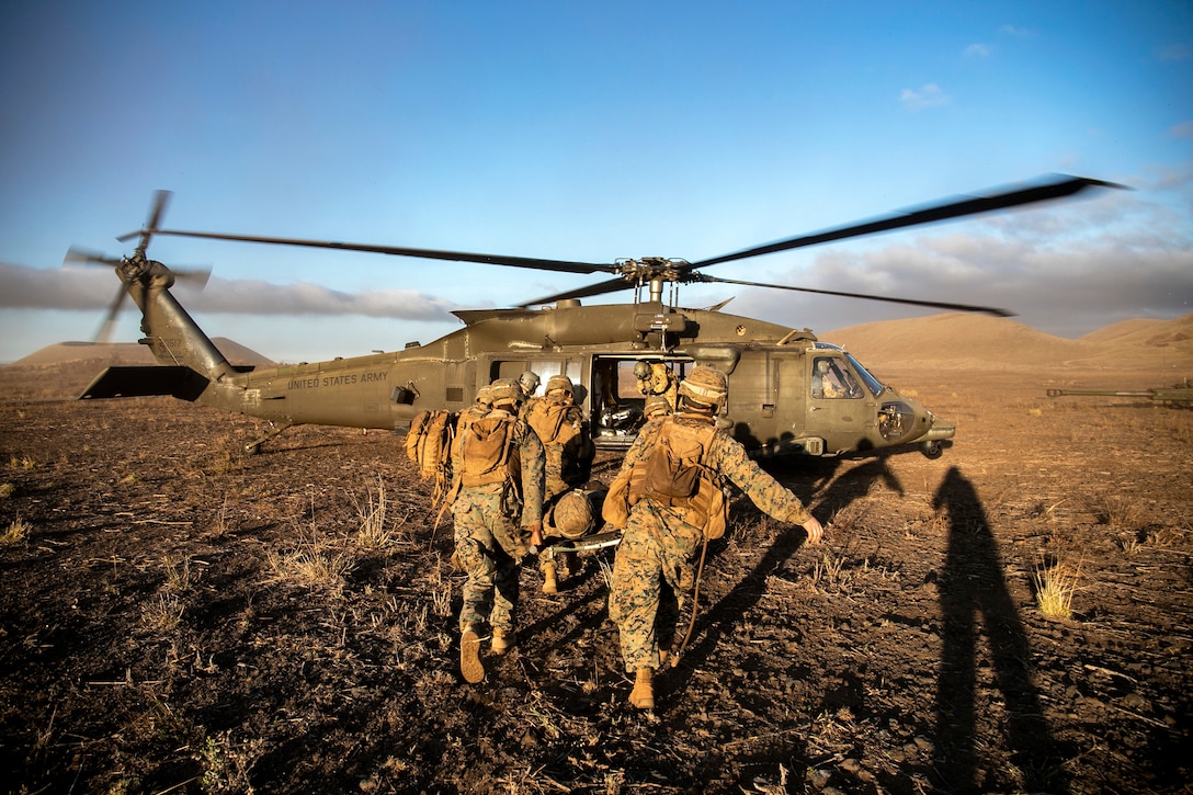 U.S. Marines and a U.S. Navy corpsman prepare to load a simulated casualty onto a U.S. Army UH-60 helicopter during a casualty evacuation drill aboard Pohakuloa Training Area, Hawaii, Sept. 20.