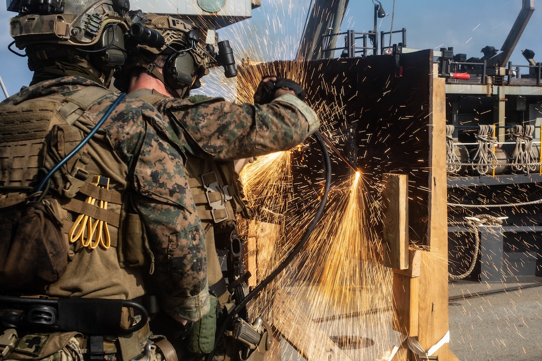 U.S. Marines cut through metal during a simulated Visit, Board, Search and Seizure mission drills aboard dock landing ship USS Germantown (LSD 42), Sept. 5.