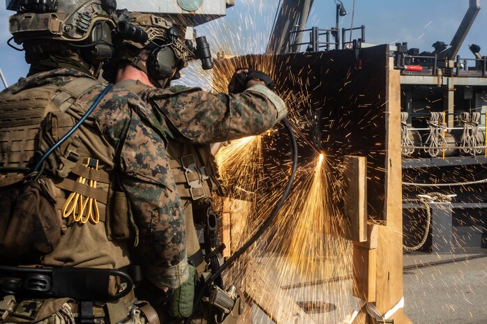 U.S. Marines cut through metal during a simulated Visit, Board, Search and Seizure mission drills aboard dock landing ship USS Germantown (LSD 42), Sept. 5.