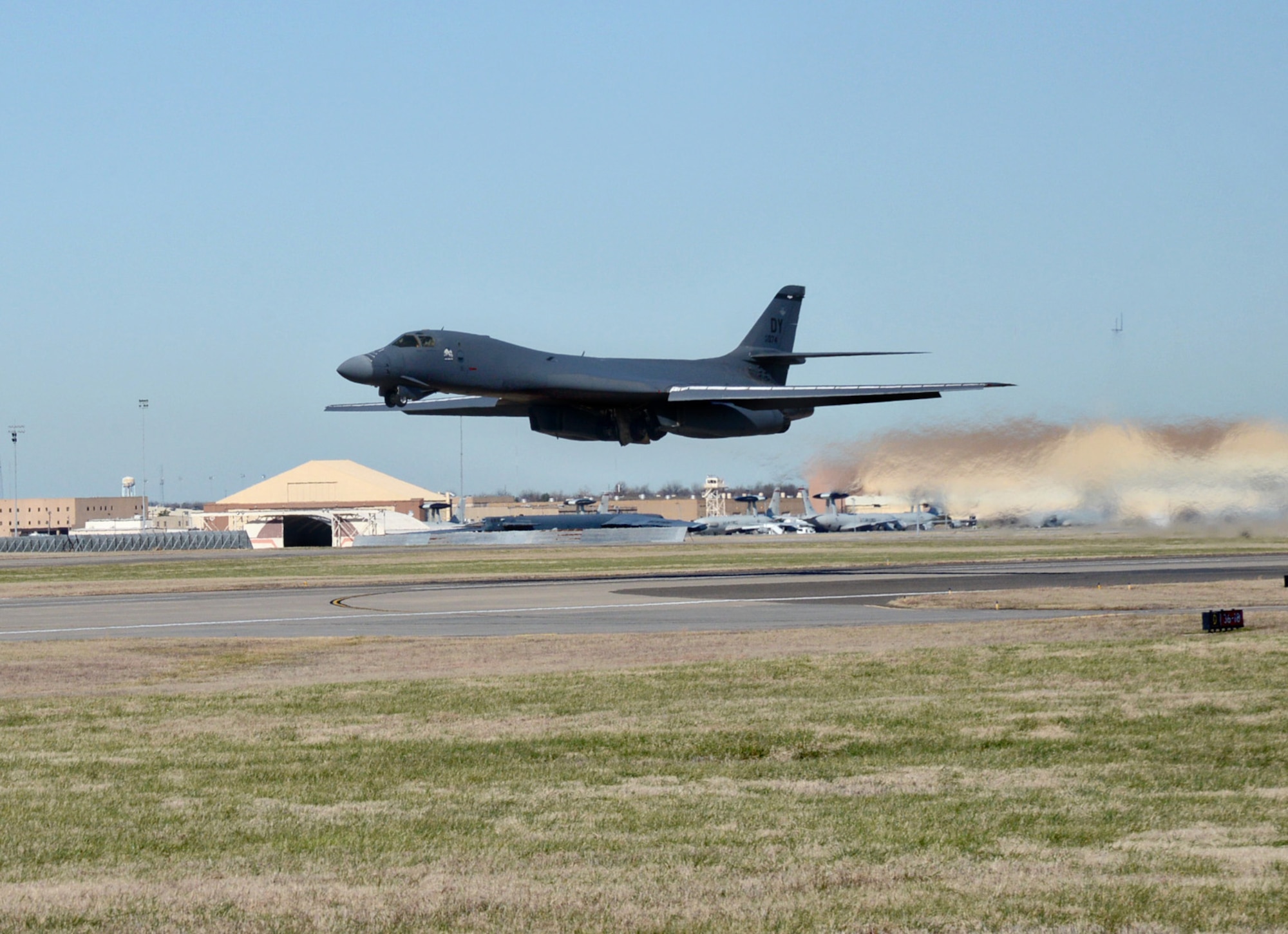 B-1 aircraft in flight above runway