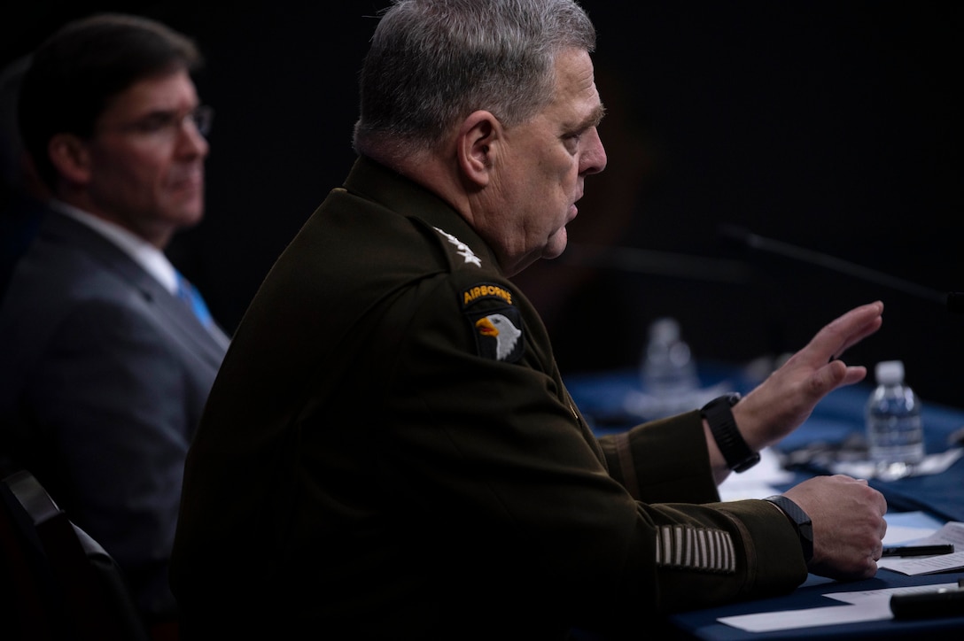 Army Gen. Mark A. Milley gestures while sitting and speaking at a table.