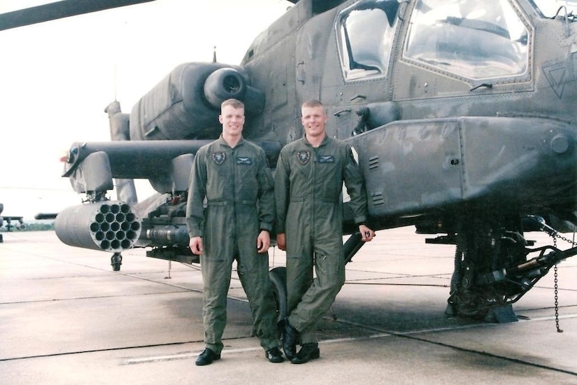Picture 5: Chief Warrant Officer 4 Isaac Smith (left) and Chief Warrant Officer 4 Stewart Smith (right) pose in 2003 next to an APH-64 Apache helicopter. (Courtesy photo by CW4 Isaac and Stewart Smith)
