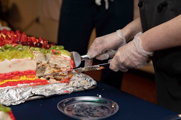 Culinary Specialist Seaman Kelly Kanungo cuts a cake during a Hispanic heritage event aboard the Wasp-class amphibious assault ship USS Kearsarge (LHD 3).