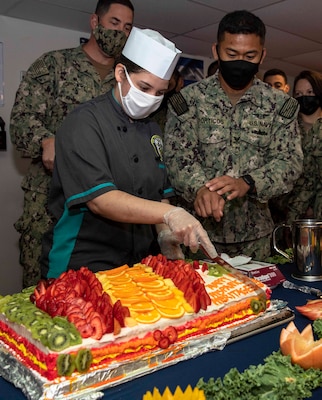 Culinary Specialist Seaman Kelly Kanungo, left, and Aviation Ordnanceman 2nd Class Leogene Porticos cut a cake during a Hispanic heritage event aboard Kearsarge.