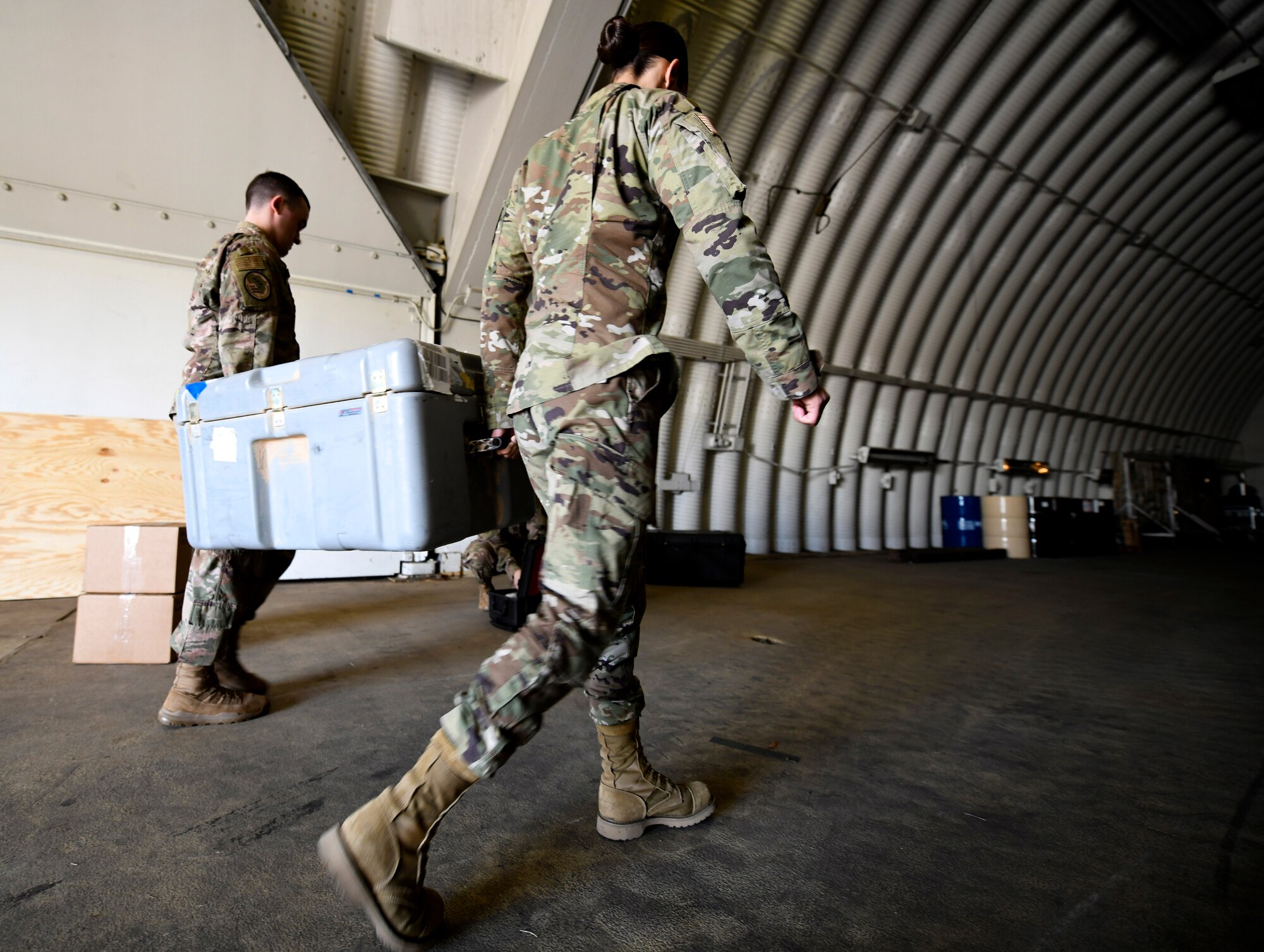 Tech. Sgt. Alicia Bertoch, 435th Air Expeditionary Wing surgeon general office flight chief, right, and Staff Sgt. Clayton Bessette, 435th AEW biomedical equipment technician, carry a case of bioenvironmental equipment at Ramstein Air Base, Germany, Sept. 22, 2020. In addition to supply and logistics, the SG team services all equipment and provides readiness capabilities for personnel deploying and redeploying to Africa. (U.S. Air Force photo by Senior Airman Madeline Herzog)