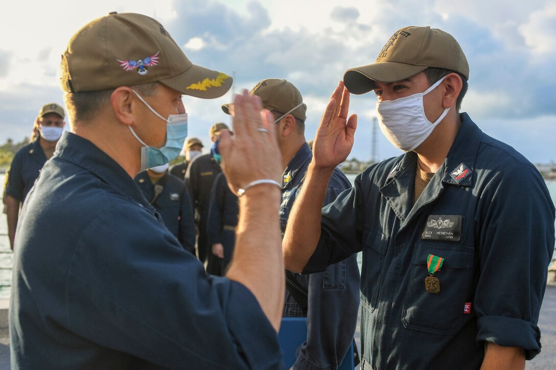 wo sailors salute each other.
