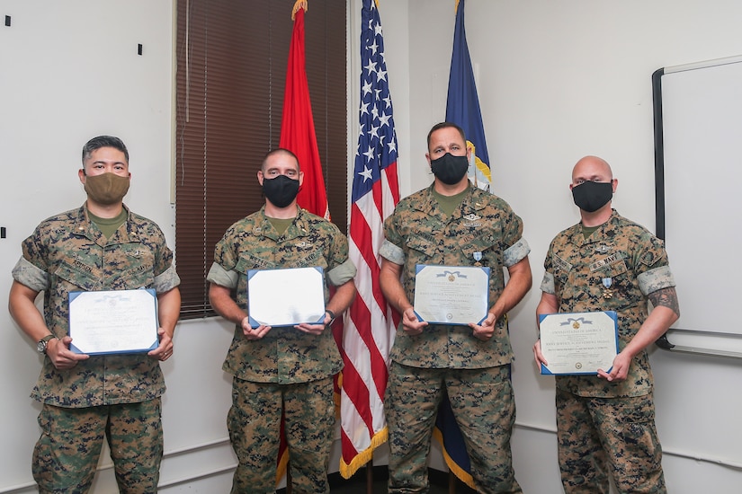 Sailors pose for a photo at an award ceremony.