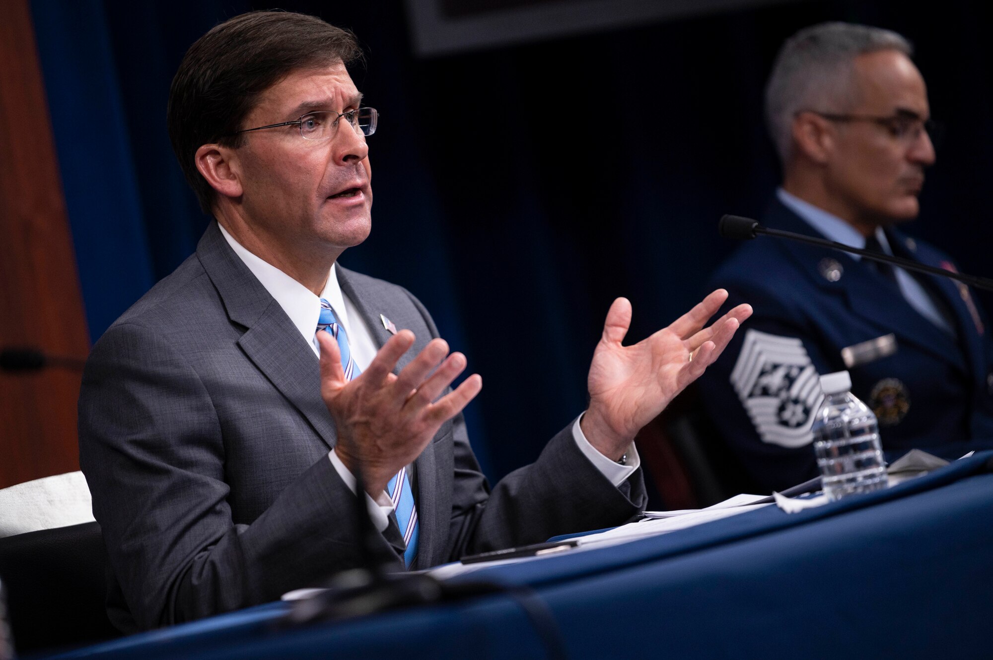 Defense Secretary Dr. Mark T. Esper gestures while sitting and speaking at the Pentagon.