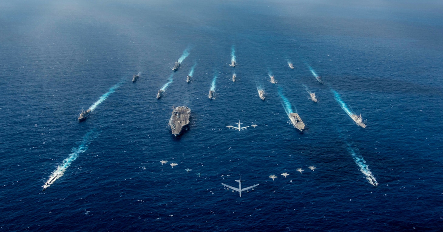 In this file photo, U.S. Navy and Japan Maritime Self-Defense Force ships steam in formation as U.S. and Japanese aircraft fly overhead during exercise Keen Sword in 2018. (U.S. Navy/MC2 Kaila V. Peters)