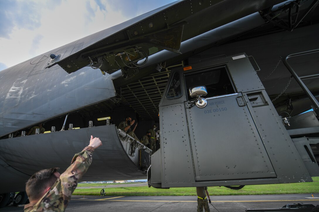 Airmen from the special handling shop direct a 60K operator for a cargo download