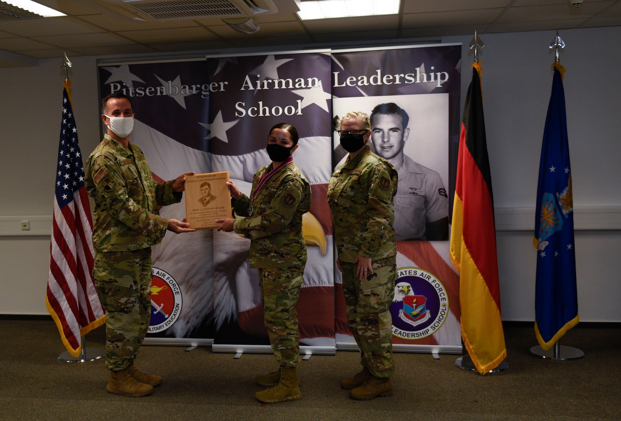 U.S. Air Force Col. Jason Hokaj, 52nd Fighter Wing vice commander, left, presents the John L. Levitow award to Senior Airman Esther Ababa, 52nd Fighter Wing Command Post member, during the Pitsenbarger Airman Leadership School class 20-G graduation at Spangdahlem Air Base, Germany, September 25, 2020. The award is given to the ALS graduate who demonstrates the most outstanding professional leadership and academic performance. (U.S. Air Force photo by Senior Airman Melody W. Howley)