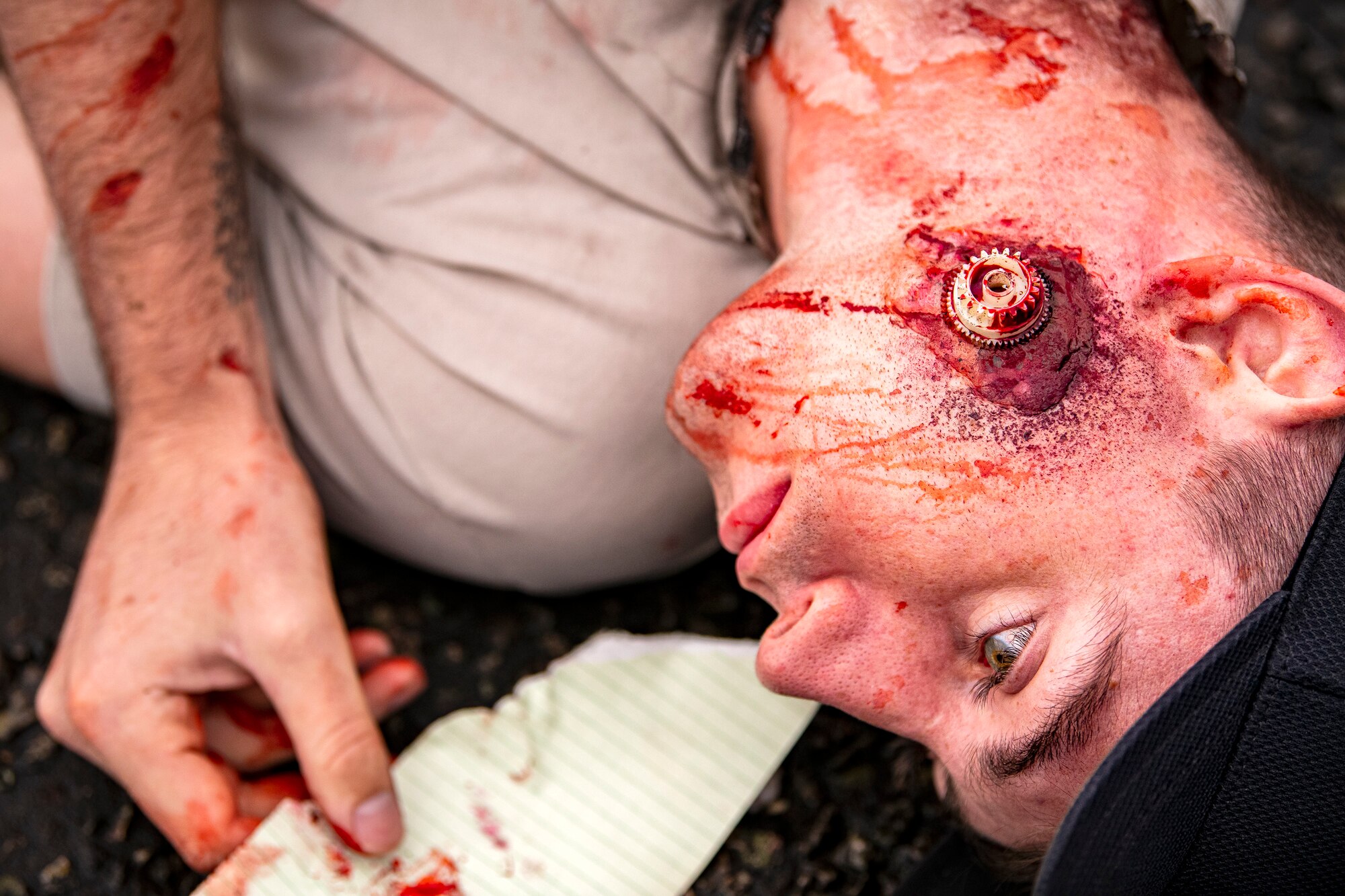 U.S. Air Force Senior Airman Kenneth Jones, 423d Communications Squadron transmission systems technician and simulated victim, lays on the ground motionless during an exercise at RAF Molesworth, England, Sept. 23, 2020.  The exercise tested Airmen and firefighter’s preparedness and interoperability by responding to a simulated drone ordinance attack. (U.S. Air Force photo by Senior Airman Eugene Oliver)