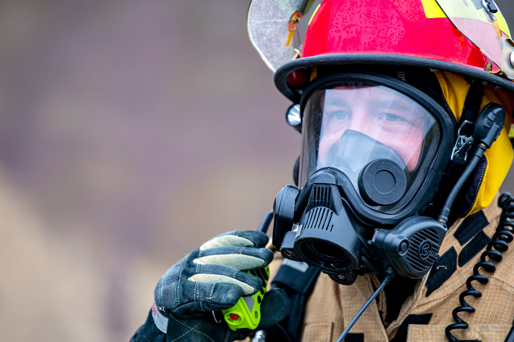 A firefighter from the 423rd Civil Engineer Squadron, communicates through a walkie-talkie during an exercise at RAF Molesworth, England, Sept. 23, 2020. The exercise tested Airmen and firefighter’s preparedness and interoperability by responding to a simulated drone ordinance attack. (U.S. Air Force photo by Senior Airman Eugene Oliver)