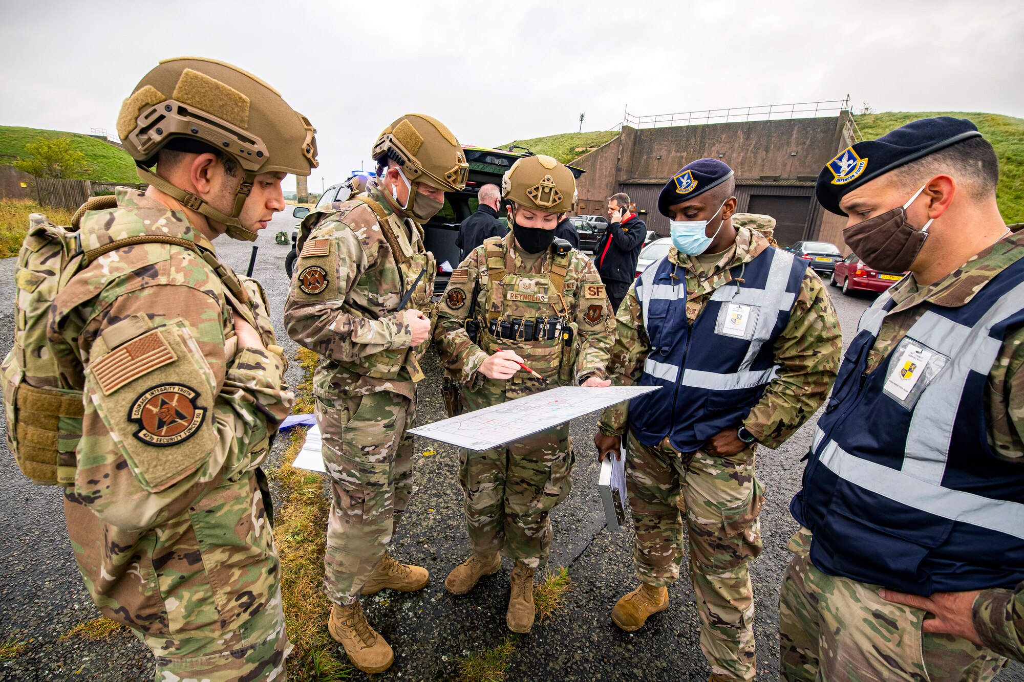 U.S. Air Force Tech Sgt. Chelsea Reynolds, center, 423rd Security Forces Squadron flight sergeant, reviews the crime scene with leadership from the 423rd SFS and Airmen from the 501st Combat Support Wing inspection team during an exercise at RAF Molesworth, England, Sept. 23, 2020. The exercise tested Airmen and firefighter’s preparedness and interoperability by responding to a simulated drone ordinance attack.(U.S. Air Force photo by Senior Airman Eugene Oliver)