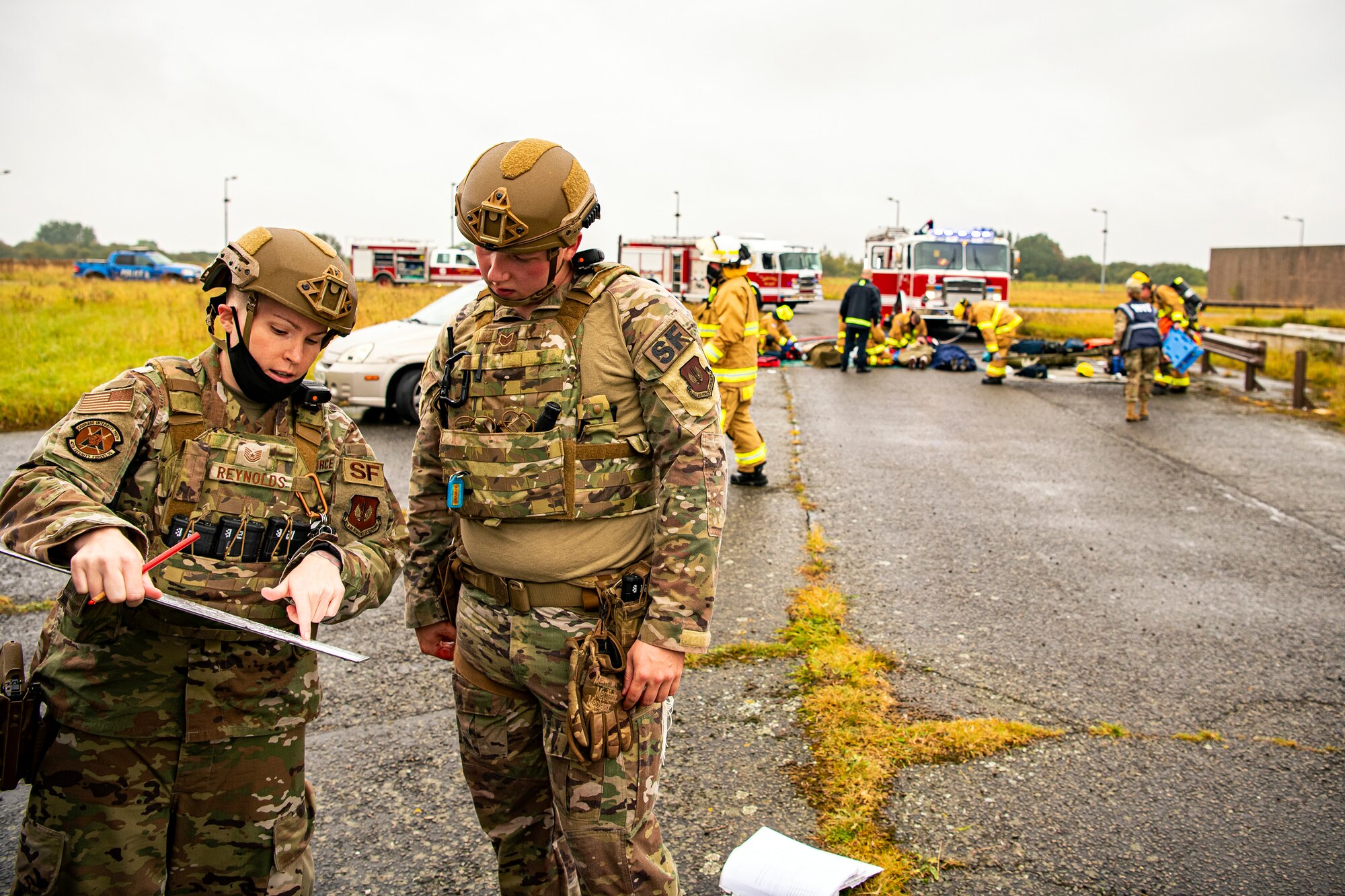 U.S. Air Force Tech. Sgt. Chelsea Reynolds, left, 423rd Security Forces Squadron flight sergeant, discusses the crime scene with Staff Sgt. Scott Marvin, right, 423rd SFS systems flight sergeant, during an exercise at RAF Molesworth, England, Sept. 23, 2020. The exercise tested Airmen and firefighter’s preparedness and interoperability by responding to a simulated drone ordinance attack. (U.S. Air Force photo by Senior Airman Eugene Oliver)