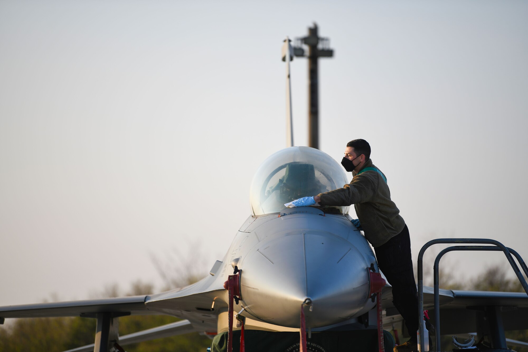 U.S. Air Force Staff Sgt. Travis Martinez, 31st Aircraft Maintenance Squadron dedicated crew chief, cleans a forward transparency window during exercise Thracian Viper 20, Sept. 24, 2020, at Graf Ignatievo Air Base, Bulgaria. U.S. Airmen perform daily tasks to ensure the aircrafts are airworthy and mission-ready for pilots to complete their variety of missions during Thracian Viper 20. U.S. Airmen participated in the multilateral training exercise, which allowed both U.S. Airmen and Bulgarian forces to extend their joint warfighting capability through operational and tactical training. (U.S. Air Force photo by Airman 1st Class Ericka A. Woolever)