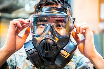 U.S. Air Force Senior Airman Tommy Pham, 422d Security Forces Squadron installation patrolman, adjusts his gas mask during a Chemical, Biological, Radiological, Nuclear and Explosives class at RAF Alconbury, England, Sept. 22, 2020. The 501st Combat Support Wing conducted an exercise to test Airmen’s preparedness and interoperability by training them to combat enemy attacks while also familiarizing them with mission-oriented protective posture (MOPP) gear. (U.S. Air Force photo by Senior Airman Eugene Oliver)