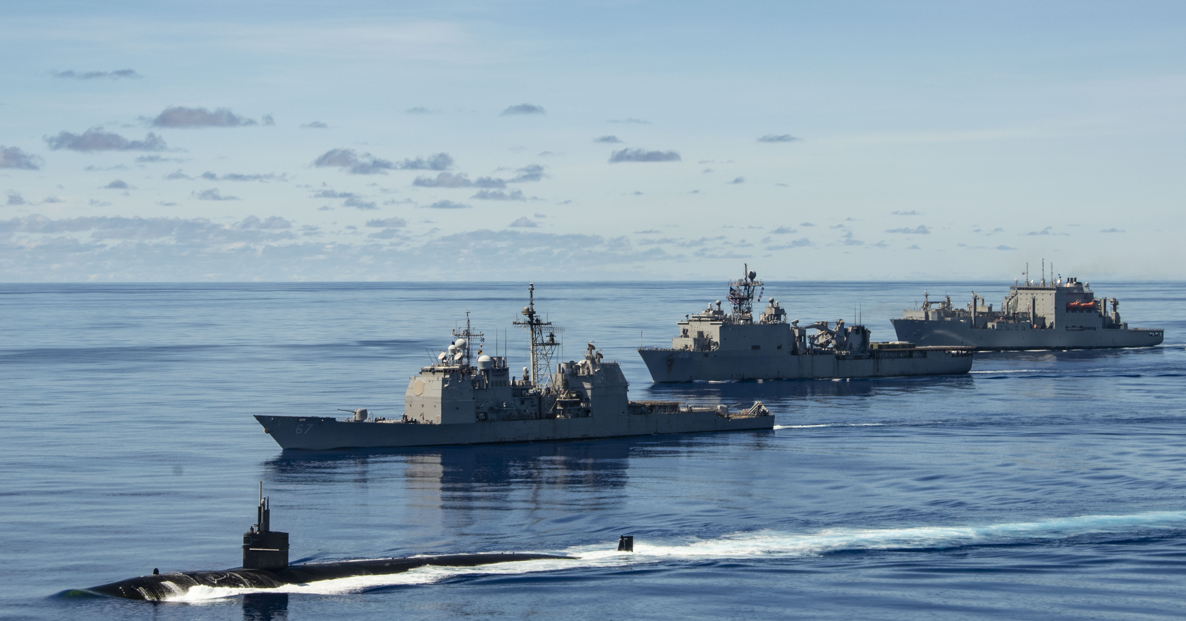 PHILIPPINE SEA (Sept. 25, 2020) USS Chicago (SSN 721), front, USS Shiloh (CG 67), USS Comstock (LSD 45), USNS Sacagawea (T-AKE 2) and USNS Charles Drew (T-AKE 10) steam in formation with the Navy’s only forward-deployed aircraft carrier USS Ronald Reagan (CVN 76), in support of Valiant Shield 2020. Valiant Shield is a U.S. only, biennial field training exercise (FTX) with a focus on integration of joint training in a blue-water environment among U.S. forces. This training enables real-world proficiency in sustaining joint forces through detecting, locating, tracking and engaging units at sea, in the air, on land and in cyberspace in response to a range of mission areas. (U.S. Navy video by Mass Communication Specialist 2nd Class Erica Bechard)