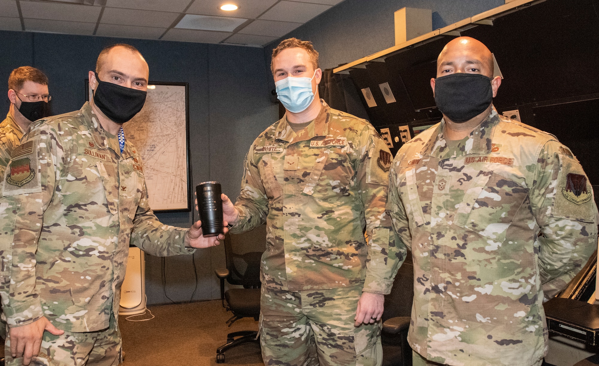 Image of an Airman accepting a Weasel of the Week award.