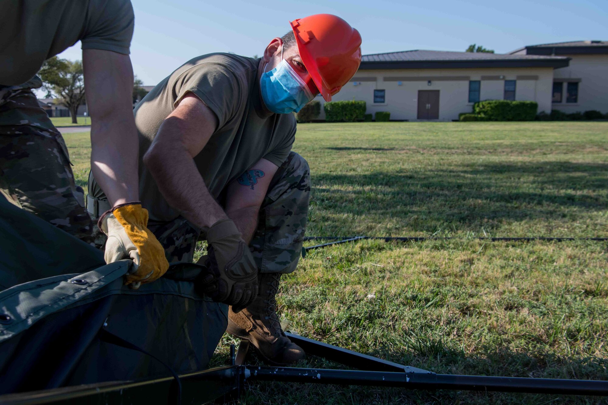 Tech. Sgt. Michael Roray, 22nd Force Support Squadron sports program manager, pulls a tent cover over a purlin Sept. 25, 2020, at McConnell Air Force Base, Kansas. The Single Pallet Expeditionary Kitchen can be deployed and operational in three hours or less by five Airmen. (U.S. Air Force photo by Airman 1st Class Marc A. Garcia)