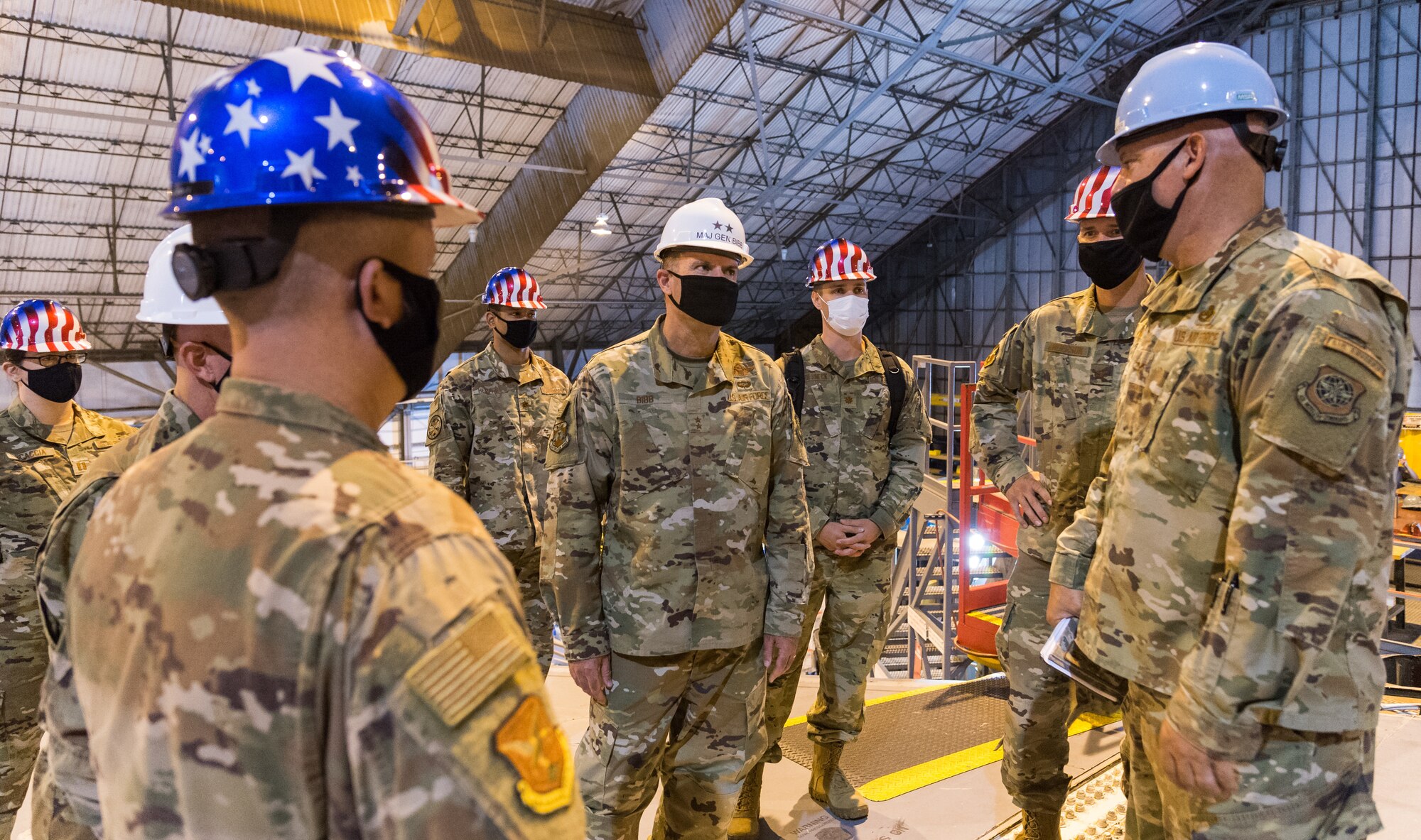 Standing on top of the wings of a C-5M Super Galaxy, Maj. Gen. Thad Bibb, 18th Air Force commander, speaks with members accompanying him during his tour of the 436th Maintenance Squadron Isochronal Maintenance Dock, Sept. 22, 2020, at Dover Air Force Base, Delaware. Dover AFB is home to the Air Force’s only isochronal maintenance dock capable of conducting major isochronal inspections of the C-5 aircraft. During a nearly 60-day inspection process, aircraft maintainers strip down the aircraft, looking for any deficiencies, faults, cracks or any other problems in every major aircraft system. (U.S. Air Force photo by Roland Balik)