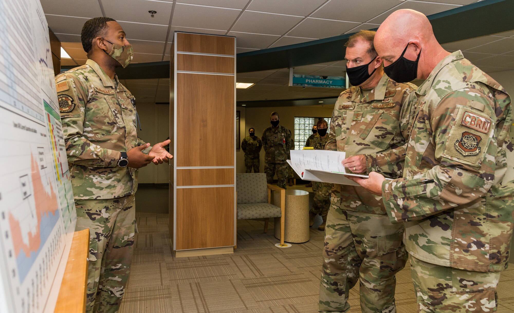 Tech. Sgt. Hezekiah Barrett, 436th Operational Medical Readiness Squadron force health management noncommissioned officer in charge, briefs Maj. Gen. Thad Bibb, 18th Air Force commander, and Chief Master Sgt. Chris Simpson, 18th Air Force command chief, on the base’s COVID-19 operations and statistics Sept. 23, 2020, at Dover Air Force Base, Delaware. Bibb and Simpson learned how the 436th Medical Group continues to battle COVID-19 by testing, monitoring trends and educating the base populace. (U.S. Air Force photo by Roland Balik)