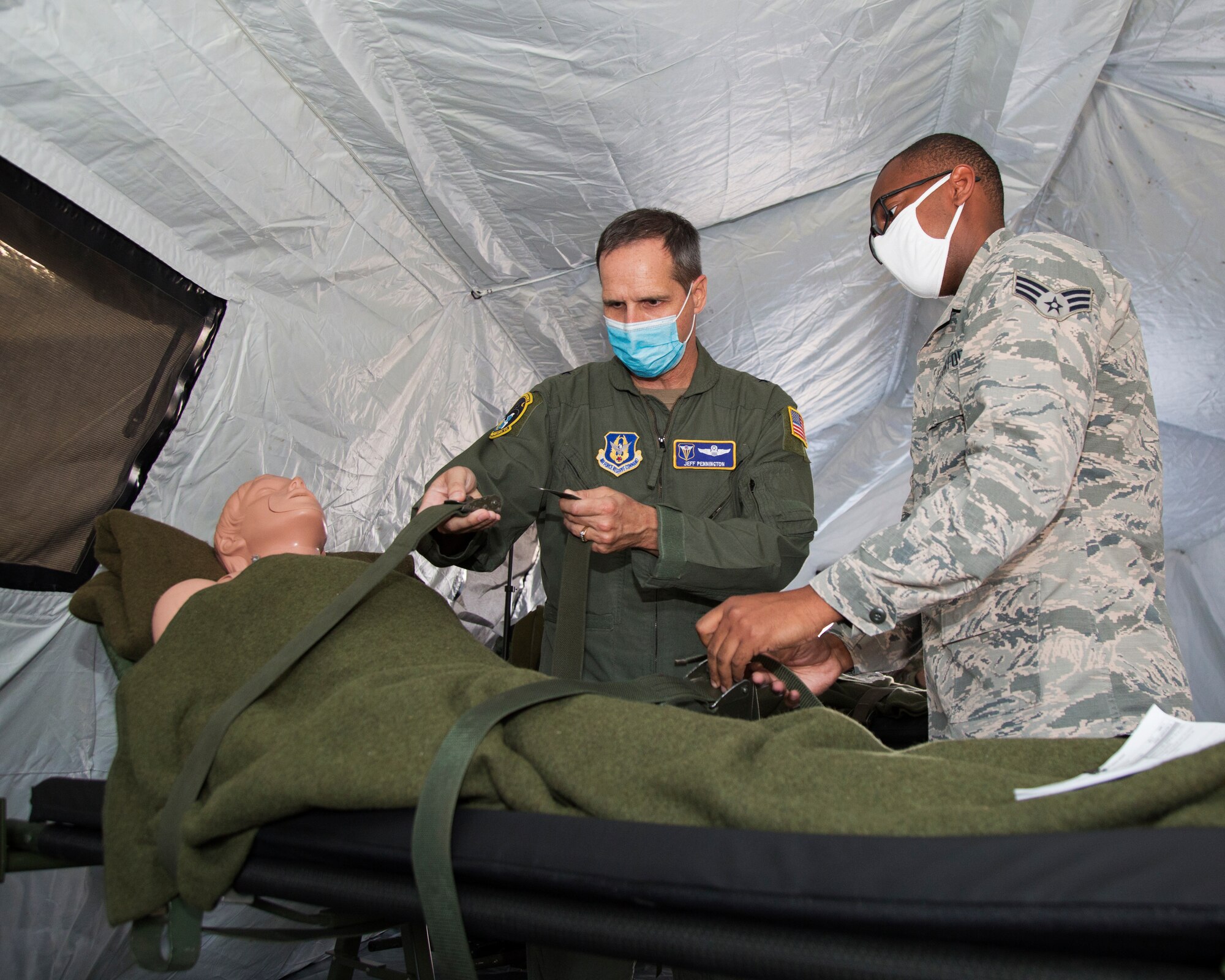 U.S. Air Force Brig. Gen. Jeffrey T. Pennington, 4th Air Force commander, secures a simulated patient with the assistance of Senior Airman Dominique M. Springs-Woodley, 446th Aeromedical Staging Squadron medical technician, on Joint Base Lewis-McChord, Washington, Sept. 9, 2020.