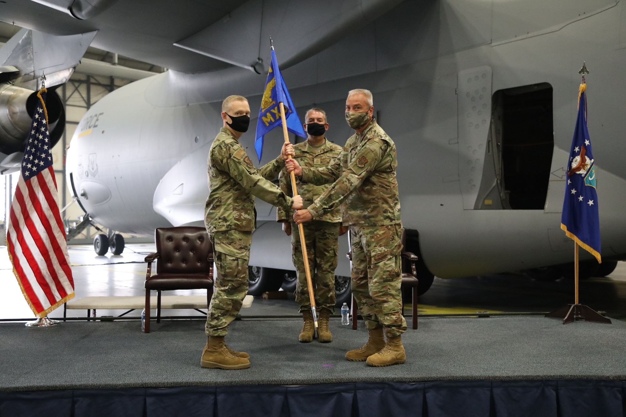 U.S. Air Force Col. John D. Norton, right, assumes command of the 446th Maintenance Group from Air Force Col. Paul Skipworth, left, 446th Airlift Wing commander, as Chief Master Sgt. Daniel Morris stands by to assist in the ceremony at Joint Base Lewis-McChord, Washington, Sept. 13, 2020