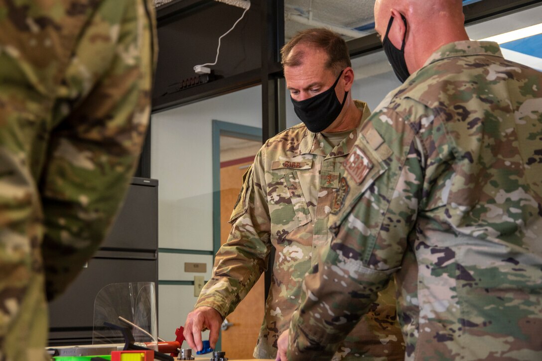 Maj. Gen. Thad Bibb, 18th Air Force commander, picks up a 3D-printed object during his tour of the new Bedrock facility at Dover Air Force Base, Delaware, Sept. 23, 2020. Established in 2019, Bedrock’s goal is empowering Airmen to develop
ideas and leverage new technologies to support the warfighter at home station or downrange. Bedrock’s new facility boasts over 5,000 square feet, housing large collaborative workspaces, an event stage, a virtual reality classroom, a podcast studio and a prototyping lab with 3D-printers. (U.S. Air Force photo by Airman Brandan Hollis)