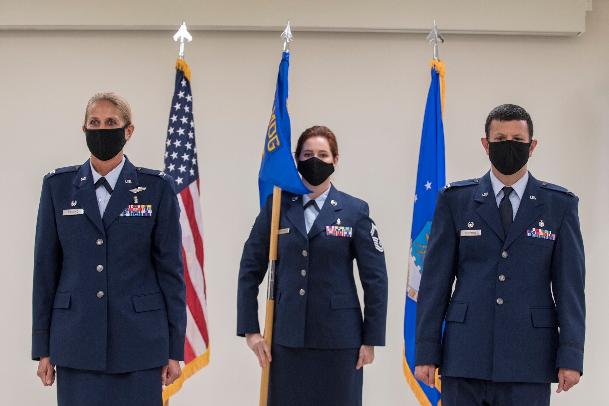 Three Airmen stand during a ceremony