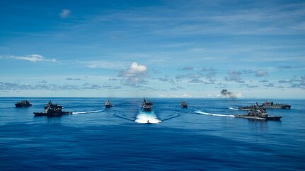 PHILIPPINE SEA (Sept. 25, 2020) From left, USNS Charles Drew (T-AKE 10), USS Comstock (LSD 45), USS Shiloh (CG 67), USS New Orleans (LPD 18), USS Chicago (SSN 721), USS America (LHA 6), USS Ronald Reagan (CVN 76), USNS John Ericsson (T-AO 194), USS Antietam (CG 54), USS Germantown (LSD 42), and USNS Sacagawea (T-AKE 2) steam in formation while E/A-18G Growlers and FA-18E Super Hornets from Carrier Air Wing (CVW) 5, a P-8 Poseidon from Commander Task Force 72, and U.S. Air Force F-22 Raptors and a B-1B Bomber fly over the formation in support of Valiant Shield 2020. Valiant Shield is a U.S. only, biennial field training exercise (FTX) with a focus on integration of joint training in a blue-water environment among U.S. forces. This training enables real-world proficiency in sustaining joint forces through detecting, locating, tracking and engaging units at sea, in the air, on land and in cyberspace in response to a range of mission areas. (U.S. Navy photo by Mass Communication Specialist 2nd Class Codie Soule)