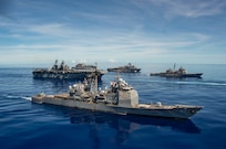 PHILIPPINE SEA (Sept. 25, 2020) USS Shiloh (CG 67), front, USS America (LHA 6), USS Antietam (CG 54), USS Germantown (LSD 42) and USNS Sacagawea (T-AKE 2), steam in formation with the Navy’s only forward-deployed aircraft carrier USS Ronald Reagan (CVN 76), in support of Valiant Shield 2020. Valiant Shield is a U.S. only, biennial field training exercise (FTX) with a focus on integration of joint training in a blue-water environment among U.S. forces. This training enables real-world proficiency in sustaining joint forces through detecting, locating, tracking and engaging units at sea, in the air, on land and in cyberspace in response to a range of mission areas. (U.S. Navy video by Mass Communication Specialist 2nd Class Erica Bechard)