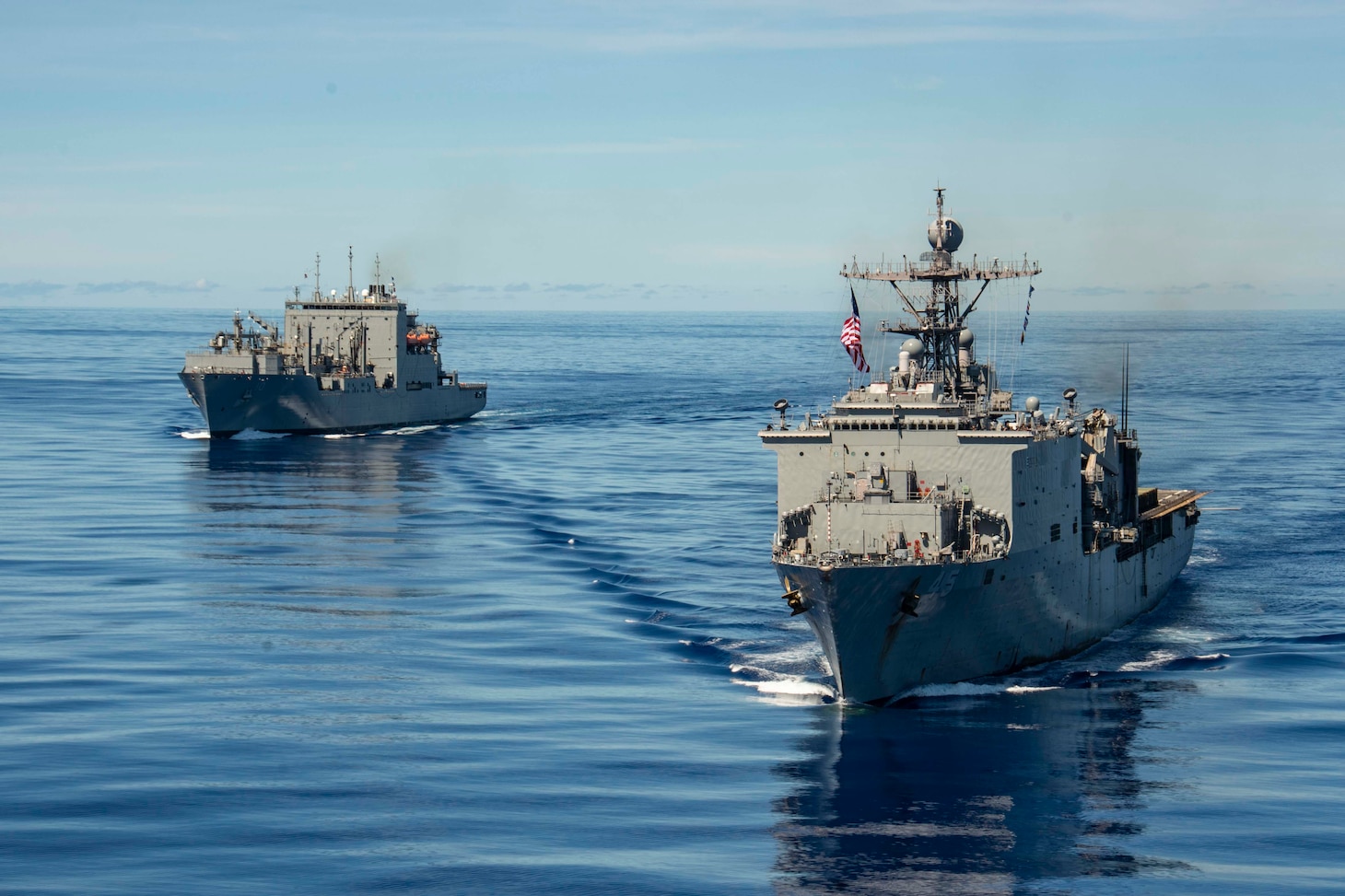 PHILIPPINE SEA (Sept. 25, 2020) USS Comstock (LSD 45), right, and USNS Charles Drew (T-AKE 10) steam in formation with the Navy’s only forward-deployed aircraft carrier USS Ronald Reagan (CVN 76), in support of Valiant Shield 2020. Valiant Shield is a U.S. only, biennial field training exercise (FTX) with a focus on integration of joint training in a blue-water environment among U.S. forces. This training enables real-world proficiency in sustaining joint forces through detecting, locating, tracking and engaging units at sea, in the air, on land and in cyberspace in response to a range of mission areas. (U.S. Navy video by Mass Communication Specialist 2nd Class Erica Bechard)
