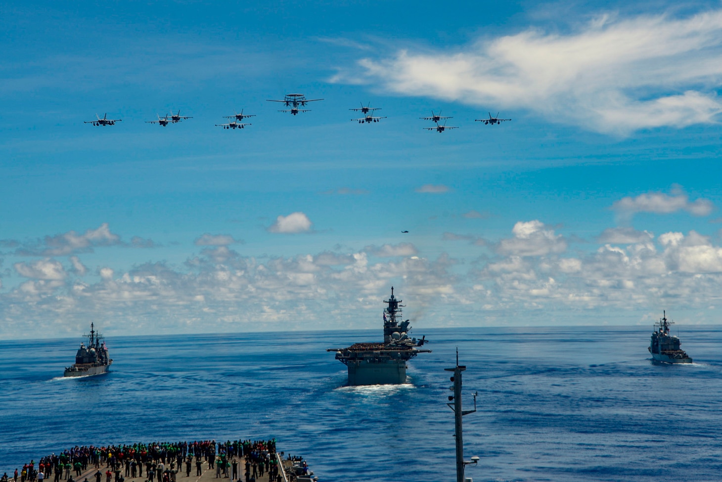 200925-N-BR419-1055 PHILIPPINE SEA (Sept. 25, 2020) From left, USS Antietam (CG 54), USS Ronald Reagan (CVN 76), USS America (LHA 6), USS Shiloh (CG 67), steam in formation while E/A-18G Growlers and FA-18E Super Hornets from Carrier Air Wing (CVW) 5, fly over the formation in support of Valiant Shield 2020. Valiant Shield is a U.S. only, biennial field training exercise (FTX) with a focus on integration of joint training in a blue-water environment among U.S. forces. This training enables real-world proficiency in sustaining joint forces through detecting, locating, tracking and engaging units at sea, in the air, on land and in cyberspace in response to a range of mission areas. (U.S. Navy photo by Mass Communication Specialist Seaman Apprentice Oswald Felix Jr.)