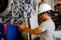 Staff Sgt. Benjamin Hetzel connects hoses on a C-146A engine as part of routine maintenance. (Dan Maffett)