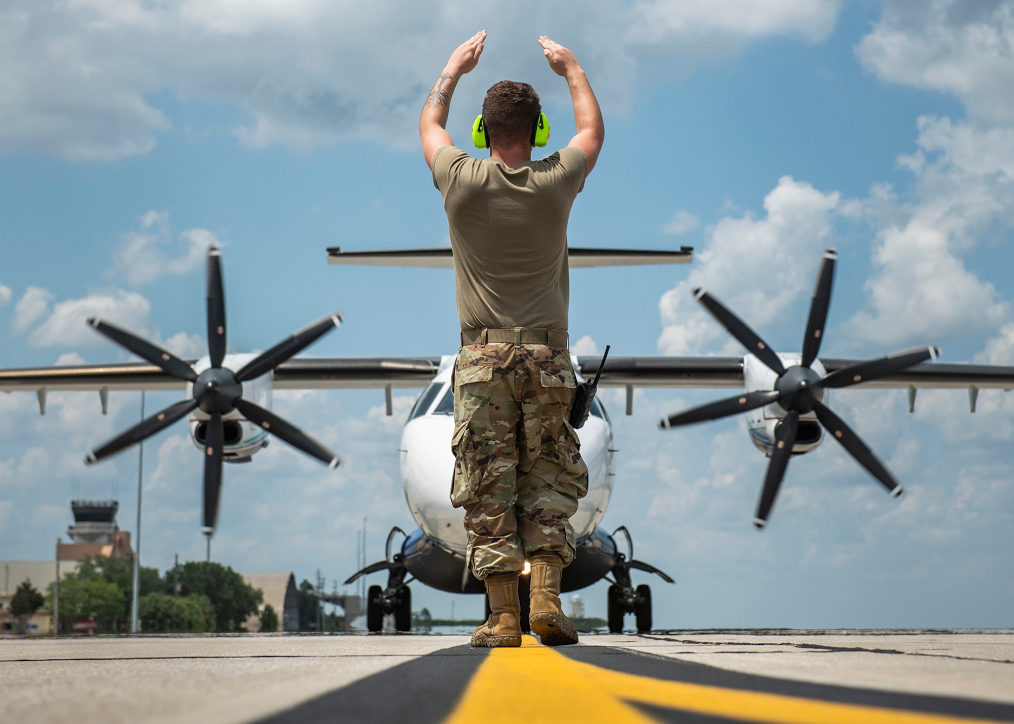 Senior Airman Gaven Browning marshals a C-146A into place. (Senior Airman Dylan Gentile)